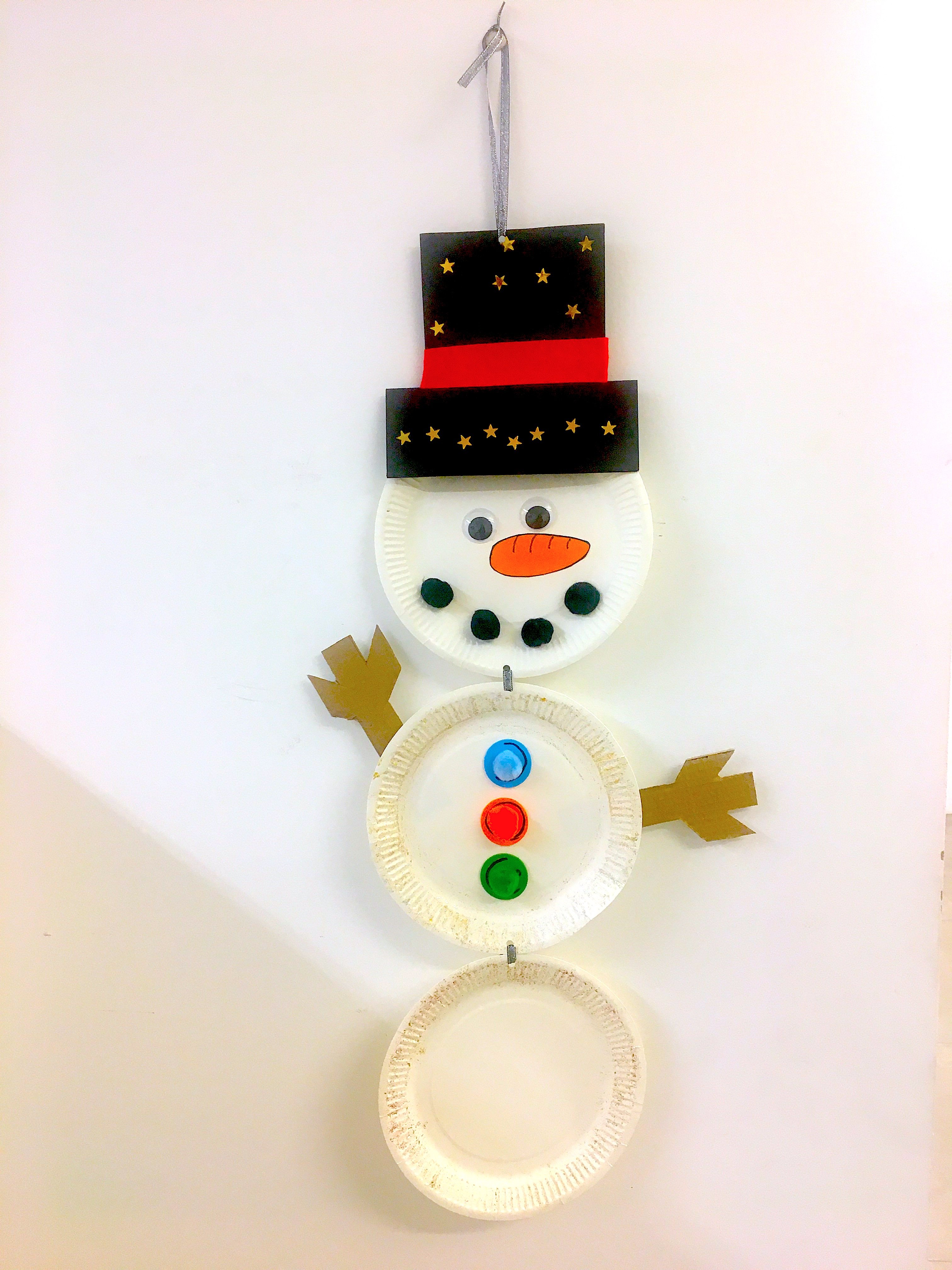 stick pom poms on the paper plate snowman